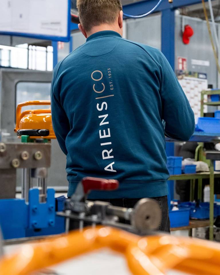 Factory worker of AriensCo EMEAA wearing their new turquise work wear inside their factory in Bühlertann, Germany